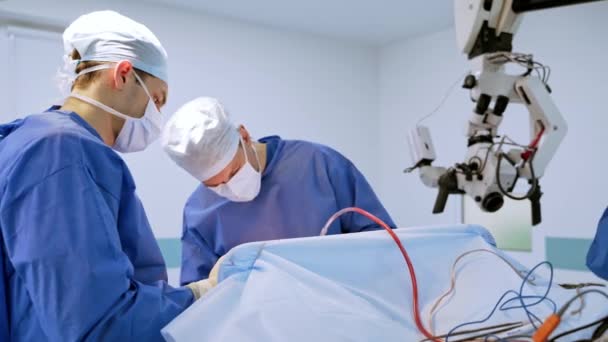 用于手术室手术的现代显微镜 一组在工作中使用手术显微镜的外科医生 — 图库视频影像