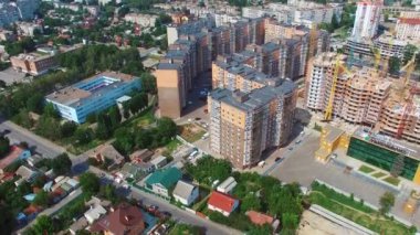 Şehirdeki inşaat alanında. Şehir merkezinde modern bölge binası. Kentsel arka planda yeni yerleşim alanı. Hava görünümü.