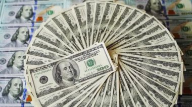 Doların zengin bir geçmişi var. Çember şeklinde dönen 100 dolarlık banknotlar. Masada Amerikan parası var. Dolar para birimi dönüyor.