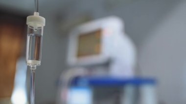 Ameliyathanede tıbbi aletler var. Geçmişi bulanık ilaçlı bir damlatıcı ve yoğun bakım ünitesinde bir bilgisayar. Yakın plan..