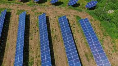 Doğanın güneş panelleri. Sahada uzun sıra mavi fotovoltaik paneller var. Sürdürülebilir enerji kaynağı. Üst hava görüntüsü.