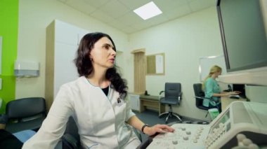 Ultrason taraması. Doktor hastanedeki bir hastanın uzi organlarını inceliyor. Kadın uzman, ultrason cihazlarıyla çalışıyor..