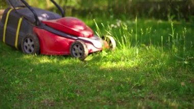 Elektrikli çim biçme makinesiyle çim biçme. Bahçedeki çimleri biçiyorum. Yaz mevsiminde bahçe işleri.