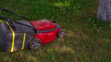 Çim biçme makinesi çim biçiyor. Çim biçme işlemi. Bahçede çalışan çim biçme makineleri..