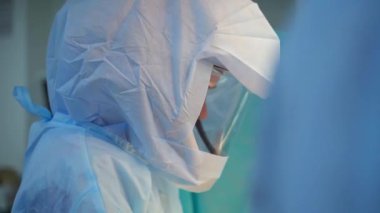 Coronavirus. Koruyucu giysili tıp çalışanları hastanede çalışıyor. Salgın sırasında klinikte cerrahi prosedür. Kritik bakım konsepti.
