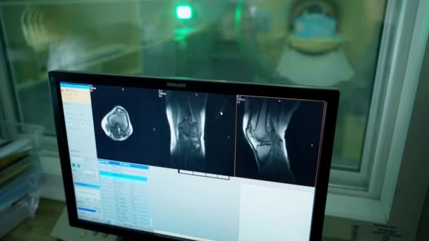 医療用コントロールルームのX線写真でモニター 病院のMriマシンの患者の間でコンピュータ画面を見ている医師 — ストック動画