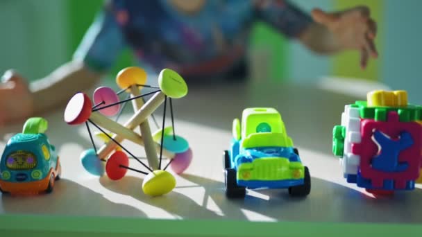 Buntes Spielzeug Auf Dem Tisch Kleiner Junge Fängt Gemeinsam Spielzeug — Stockvideo