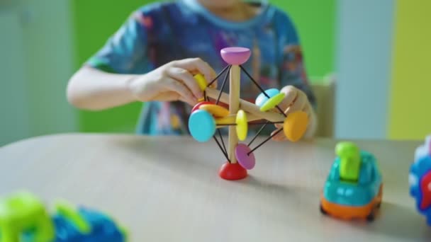 Mały Chłopiec Zabawkami Środku Dziecko Bawi Się Kolorowymi Zabawkami Stole — Wideo stockowe