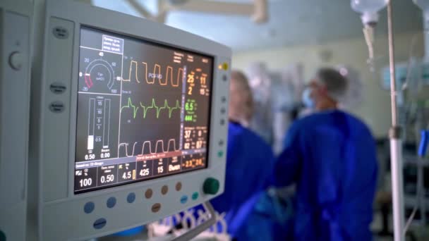 手术室里的医院监视器 在外科手术的背景下 屏幕显示了病人的生命迹象 医生的团队精神 — 图库视频影像