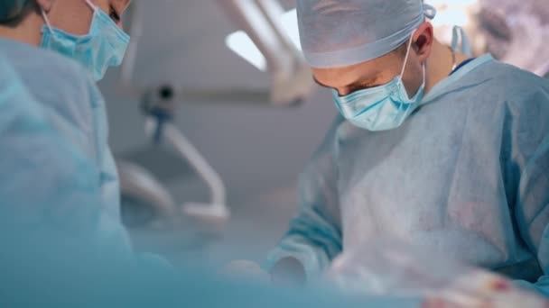 神经外科的医疗程序 在现代显微镜背景下 年轻男性外科医生和一名护士在手术室进行手术 — 图库视频影像