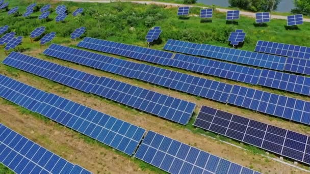 フィールド上の革新的な太陽光発電所 晴れた日の田舎のソーラーコレクターシートの上を飛ぶ 再生可能な緑のエネルギー エアリアルビュー — ストック動画