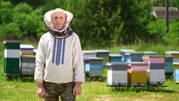 农场的养蜂人半身像披着保护帽的男性围观者的半身像 背景为围裙 天然产品的生产 4月的概念 — 图库视频影像