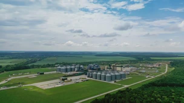 現場で穀物エレベーター付きの工業工場 美しい自然景観を背景に農業収穫ストレージ 空中風景 — ストック動画