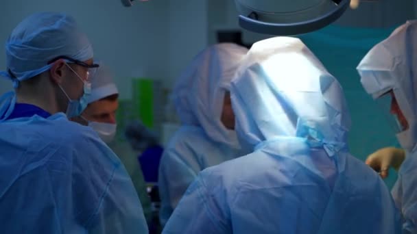 医院的外科手术 一组穿着安全衣的医生在手术室里做手术 外科医生使用医疗工具 — 图库视频影像