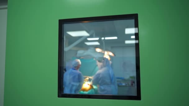 窓から手術 手術室での手術 医療専門家のグループによる操作に関するウィンドウビュー — ストック動画