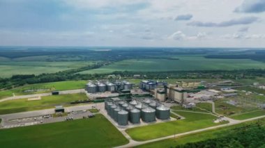 Güzel manzarada tahıl asansörleri. Tahıl ambarlı tarım fabrikası. Mısır gevreği depolamak için büyük alüminyum kaplar. Hava görünümü.