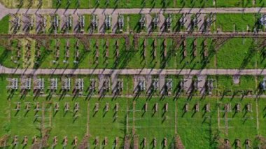 Güç iletim hatları. Yeşil alan arka planında yüksek voltajlı sütunların üzerinden uçmak. Hava görünümü.