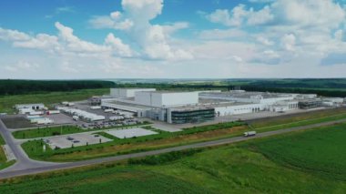 Taşrada modern bir fabrika. Yeşil doğa arasında endüstriyel alana panoramik bir bakış. Yazın tarlada büyük üretim.