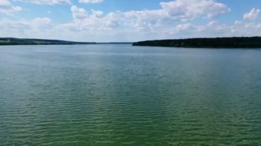 Mavi gökyüzünün altında akşam suyu. Güzel geniş nehir manzarası. Tarlalar ve ormanlar arasında sakin bir nehir. Hava Uçuşu.