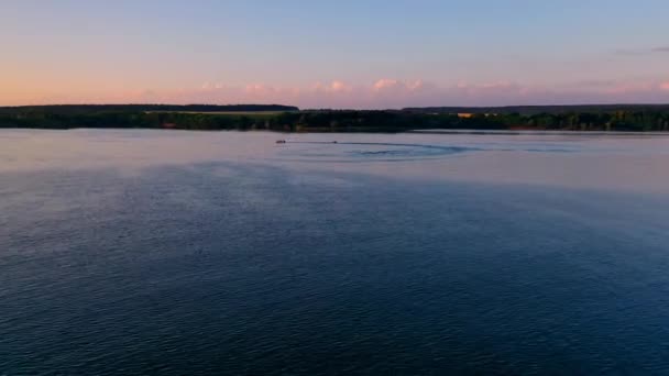 ボートは日没で航海する 産業工場の背景にある夜の川の風景 小さなボートを水に引っ張るモーターボート サマーバケーション エアリアルビュー — ストック動画
