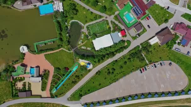 现代建筑群的全景 靠近河边有足球场和游泳池的娱乐区 绿色自然中的休息中心 高空鸟瞰 — 图库视频影像