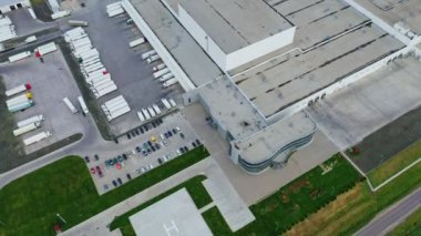 Büyük bir kompleks ve park yeri. Yazın kamyonları ve otoparkları olan sanayi binalarının çatıları. Üst hava görüntüsü.
