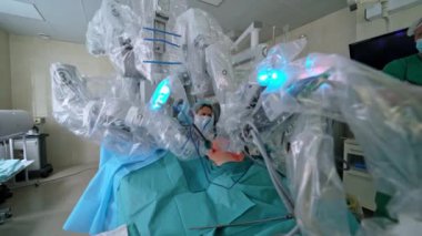 Cerrahi robotla ameliyathane. Kanserli tümör ameliyatı. Doktorlar modern tıbbi ekipmanların çalışmalarını gözlemliyor. Minimum invazif robotik cerrahi.