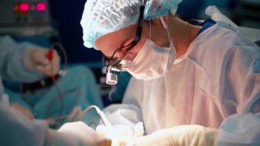 Doktor tıbbi ekipmanlarla çalışıyor. Kafasında büyüteç olan kadın bir uzman hastaya estetik ameliyat yapıyor..