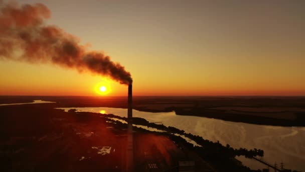 産業用パイプからの日没に対する煙 設定された太陽の川の近くの工場 大気汚染について — ストック動画