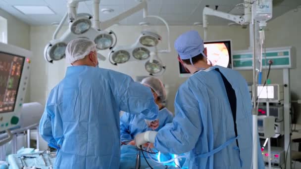 Modernt Medicinskt Operationssal Läkargruppen Opererar Patienten Och Tittar Monitorskärmen Laparoskopisk — Stockvideo