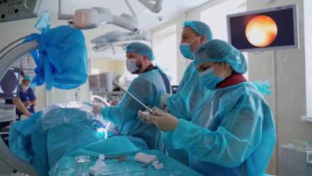 手术室的卫生工作者 身穿蓝色制服戴口罩的医学专家在现代医院为病人做手术 — 图库视频影像