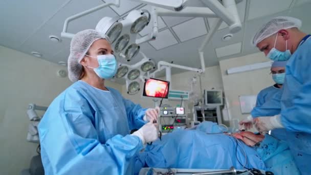 Cirurgia Por Médicos Profissionais Clínica Cirurgiões Assistentes Conversam Usam Ferramentas — Vídeo de Stock