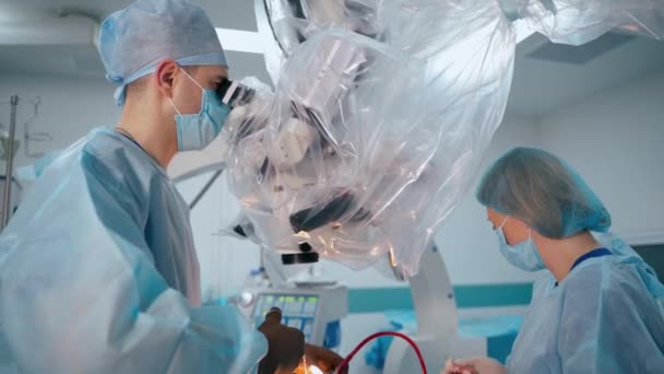 Врачи Хирургический Микроскоп Нейрохирург Медсестра Медицинской Форме Проводят Операцию Больнице — стоковое видео