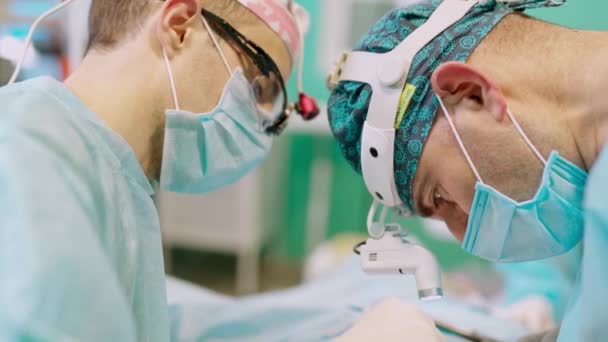 医生的脸在工作 戴口罩和头戴外科灯的医生在诊所做手术的概况介绍 后续行动 — 图库视频影像