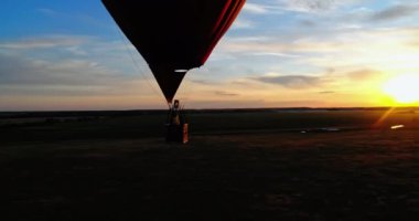Gün batımında romantik bir zeplin. Sıcak hava balonu kalp şeklinde sepeti ile yaz mevsiminde güzel akşam doğa arka planında seyahat eder..