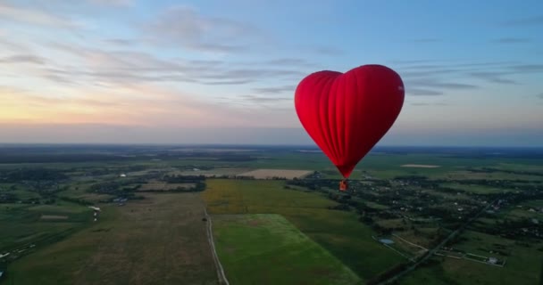 Kalp Şeklinde Bir Kırmızı Zeplin Gökyüzünde Sıcak Hava Balonu Kırsalda — Stok video