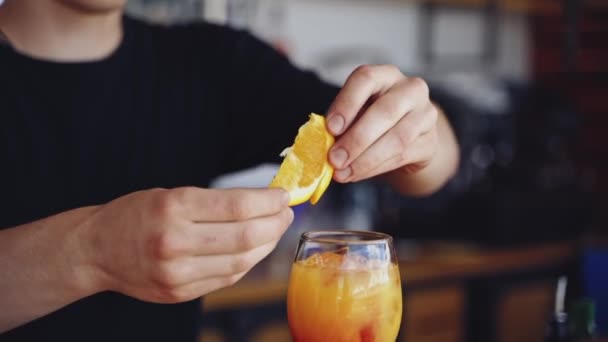 バーテーブルにカクテルを用意しました バーテンダーは 明るい飲み物でガラスの上にオレンジ色のスライスを置きます ナイトクラブで飲むグラス — ストック動画