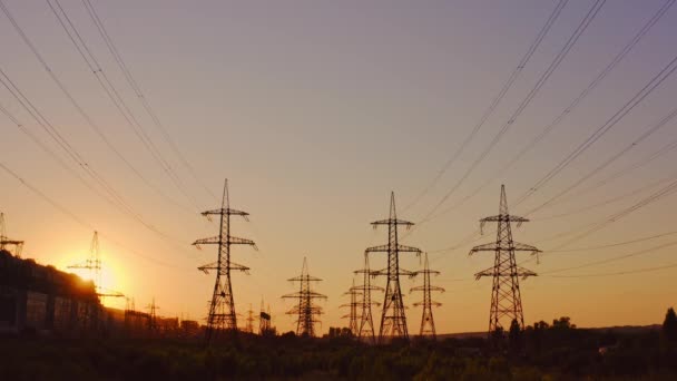 Høyspent Elektrisk Ledning Ved Solnedgang Silhuetter Elektriske Pyloner Den Innstillende – stockvideo