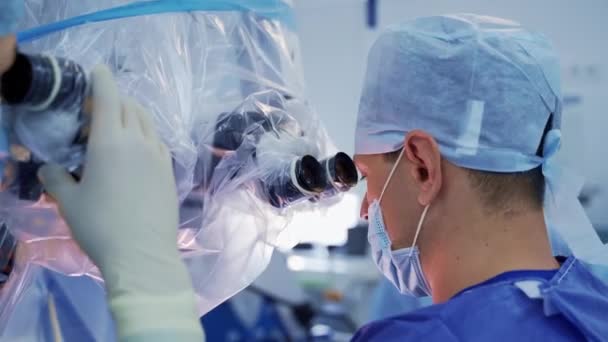 Mikroskobun Yanındaki Maskeli Doktor Bir Grup Tıp Uzmanı Hastayı Ameliyat — Stok video