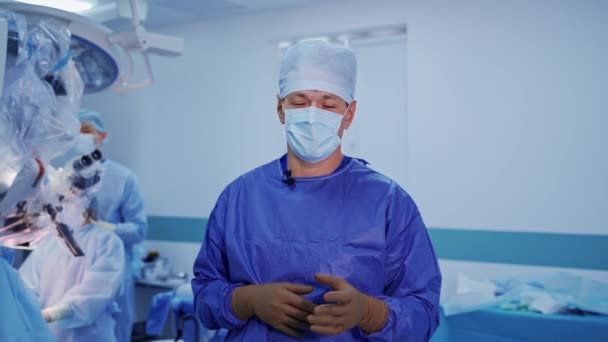 마스크를 외과의의 초상화 제복과 메마른 장갑에 직업적인 의사는 수술실에 현미경 — 비디오