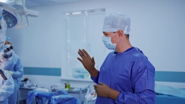 在医院开始神经外科治疗 身穿医疗制服的医生对着摄像机讲话 开始做手术 手术室的医疗工作者小组 — 图库视频影像