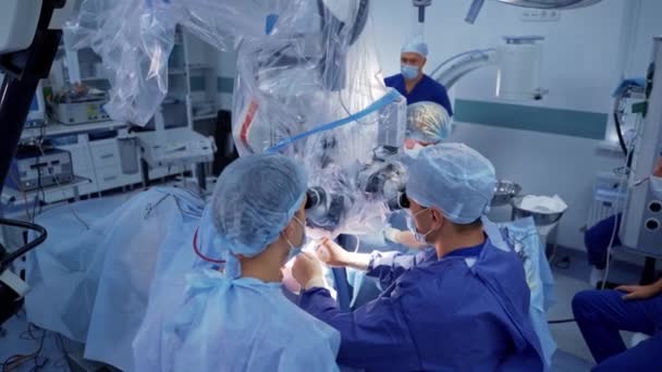 Doktoři Mikroskopem Tým Zdravotníků Modré Uniformě Operuje Pacienta Zatímco Dívá — Stock video