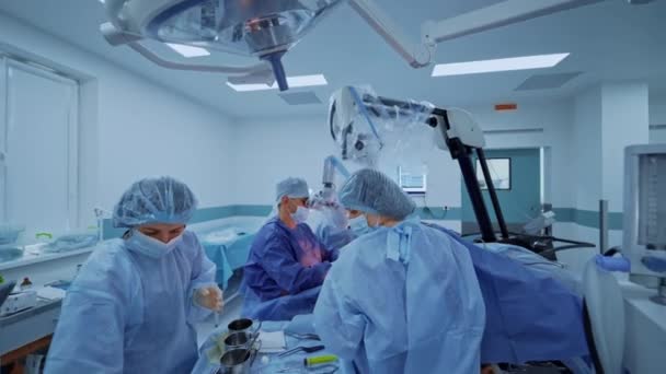 演劇のドクターのチームワーク 青い制服の医療従事者は 神経外科の新しい技術を使用して患者を操作します — ストック動画