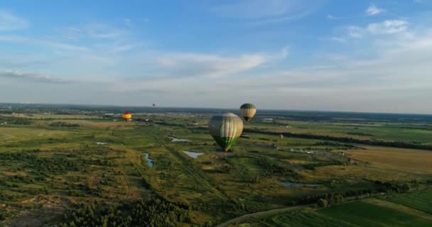 Mooie Aerostaten Lucht Verschillende Kleurrijke Heteluchtballonnen Vliegen Groene Velden Luchtvervoer — Stockvideo