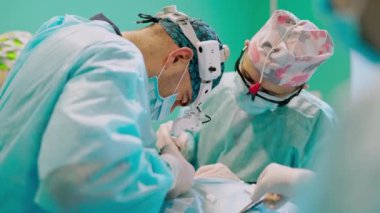 Uzmanlar tarafından cerrahi işlem. Tıp üniformalı doktorlar özel aletleri olan bir hastaya ameliyat yaparlar. Tıp konsepti.