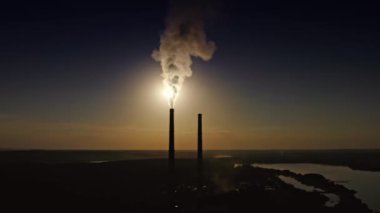 Yoğun duman karanlıkta endüstriyel borudan çıkar. Geceleri havayı zehirli dumanlar dolduruyor. Fabrikadan doğaya kirli emisyonlar. Hava görünümü.