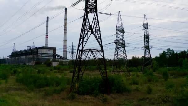 高压电塔 输电线路以工业厂房为背景 农村田里的钢制电塔 相机升起了 — 图库视频影像