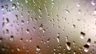 Cama damlıyor. İçeriden pencereye yağmur yağıyor. Cama yağmur yağıyor. Arka planda yağmur damlaları var. Kötü hava. Makro çekim.