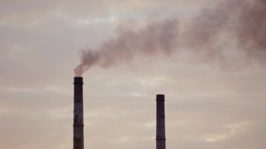 Gece gökyüzüne karşı dumanlı endüstriyel borular. Endüstriyel bacadan yayılan zararlı emisyonlar. Hava kirliliği.