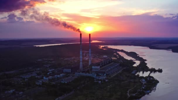 エコロジカル災害 川の近くの有害な工場は日没時に汚れた排出物を放出する 産業は環境を汚染する 美しい自然の背景に煙が付いているパイプ — ストック動画